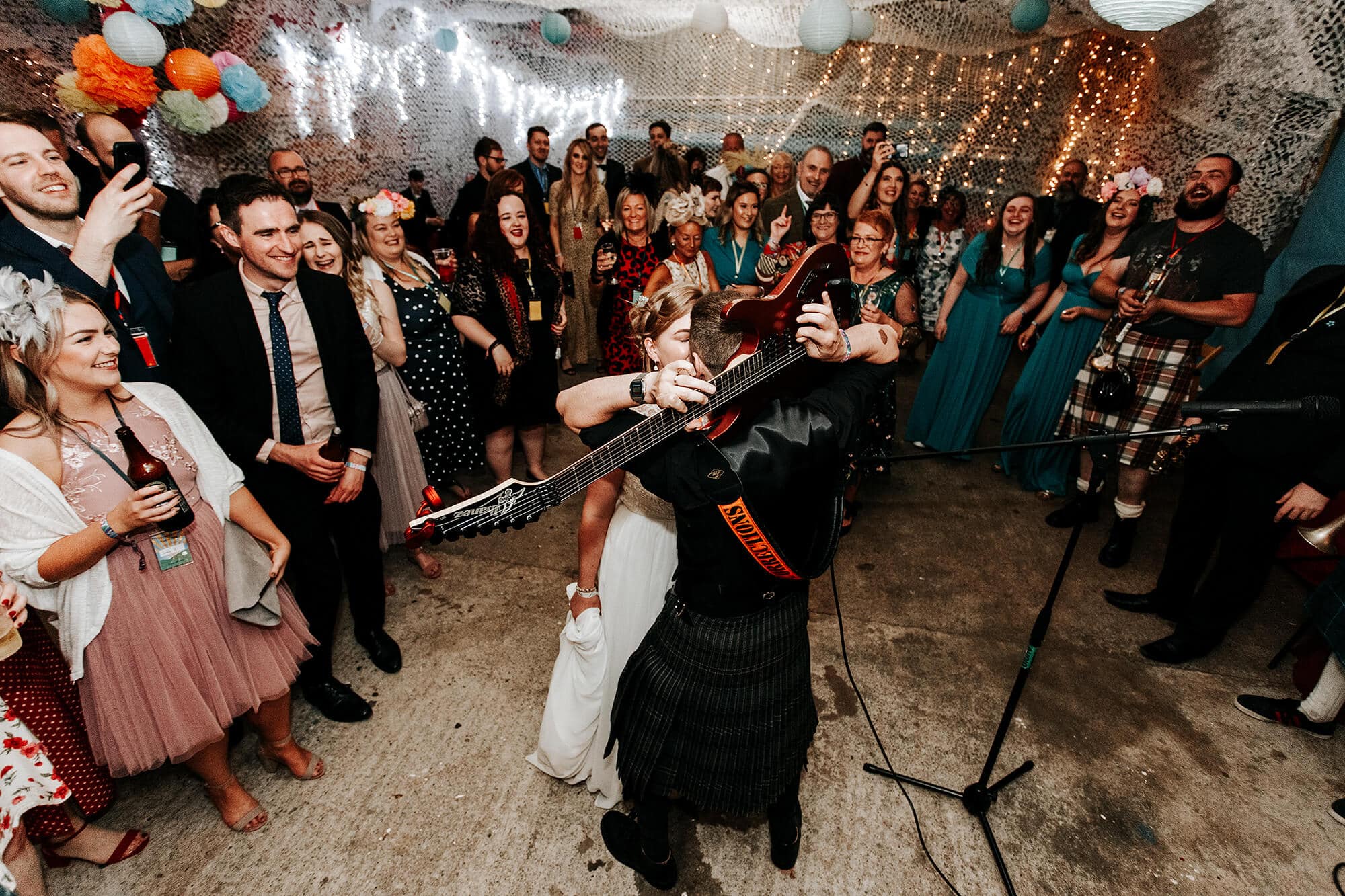 groom playing guitat for bride during evening wedding reception loch ken