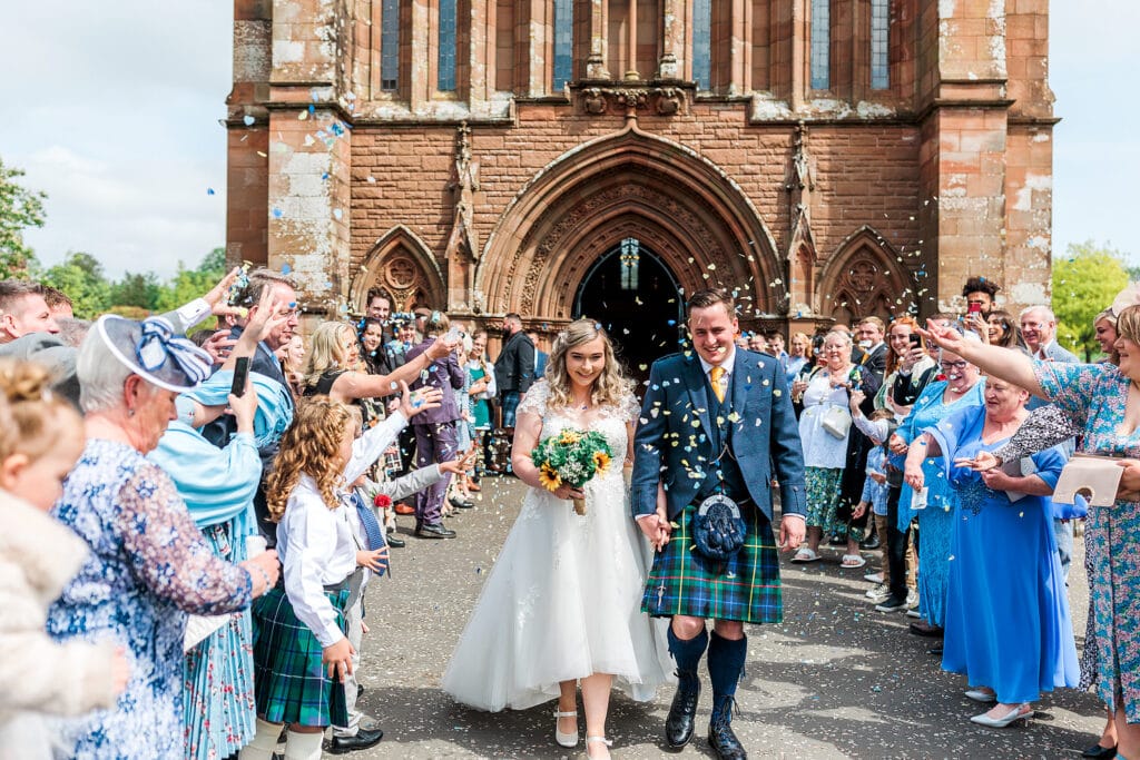 confetti shot of couple walking outside the crichton church easterbrook hall wedding